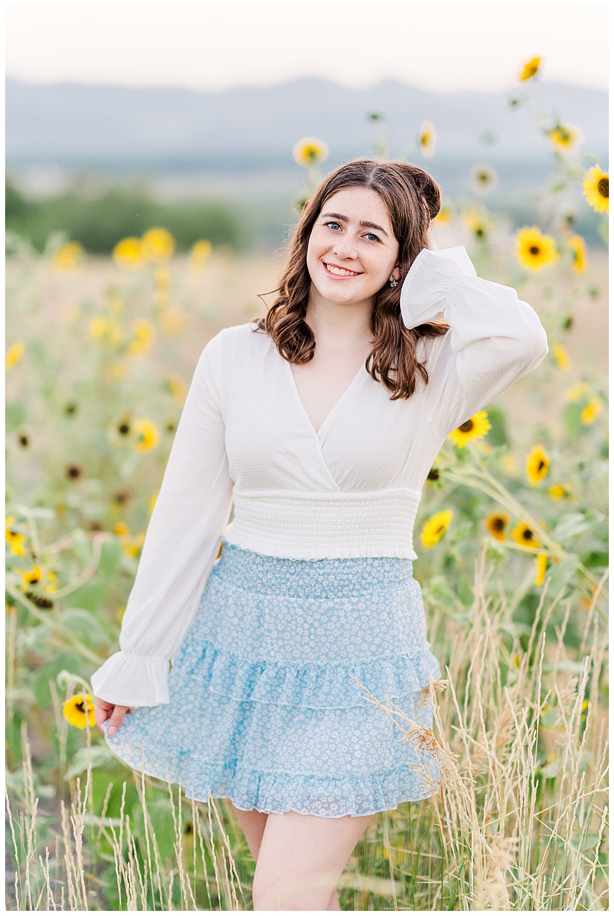 Brown hair girl with white shirt and blue skirt standing in sunflowers