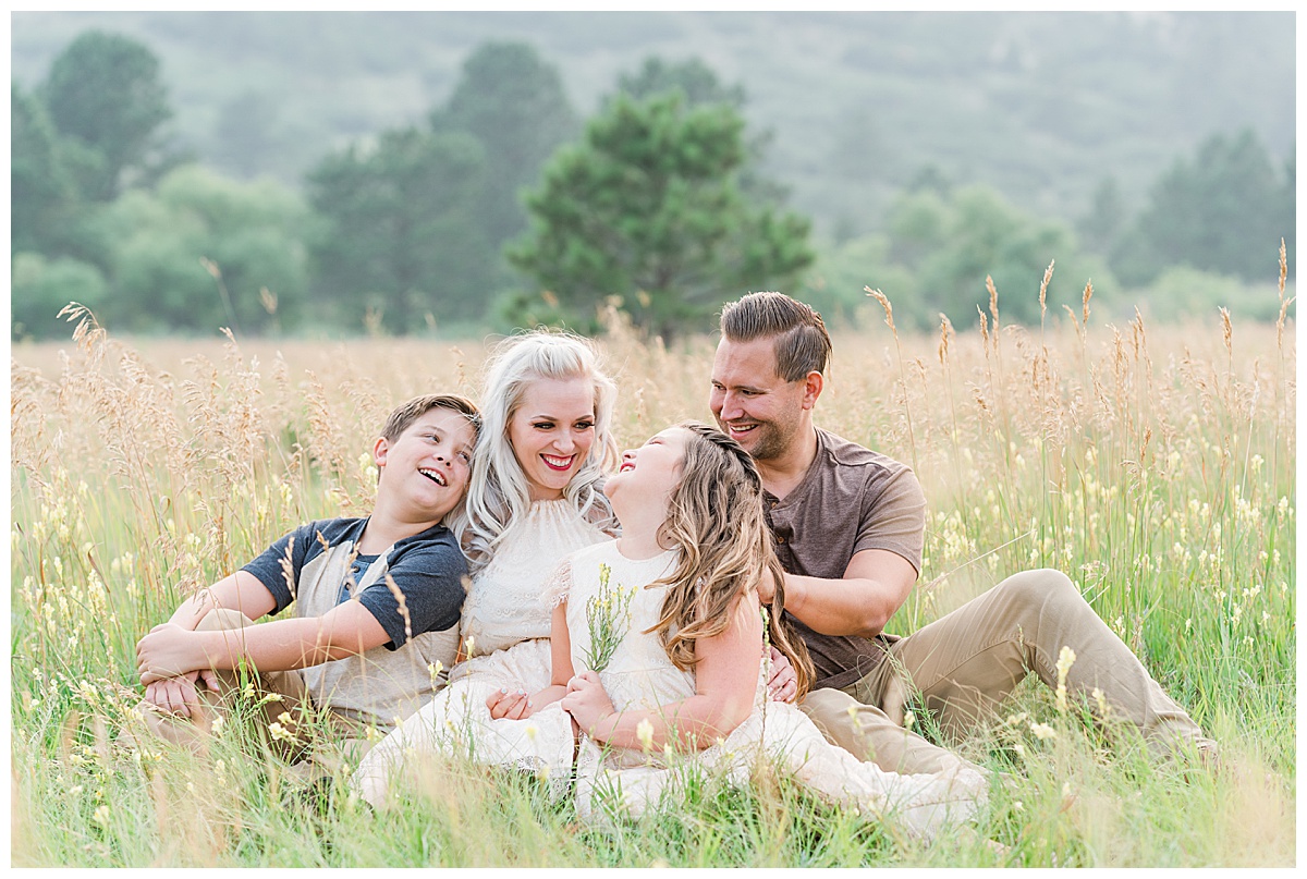 family laughs together in meadow for ute valley park photos