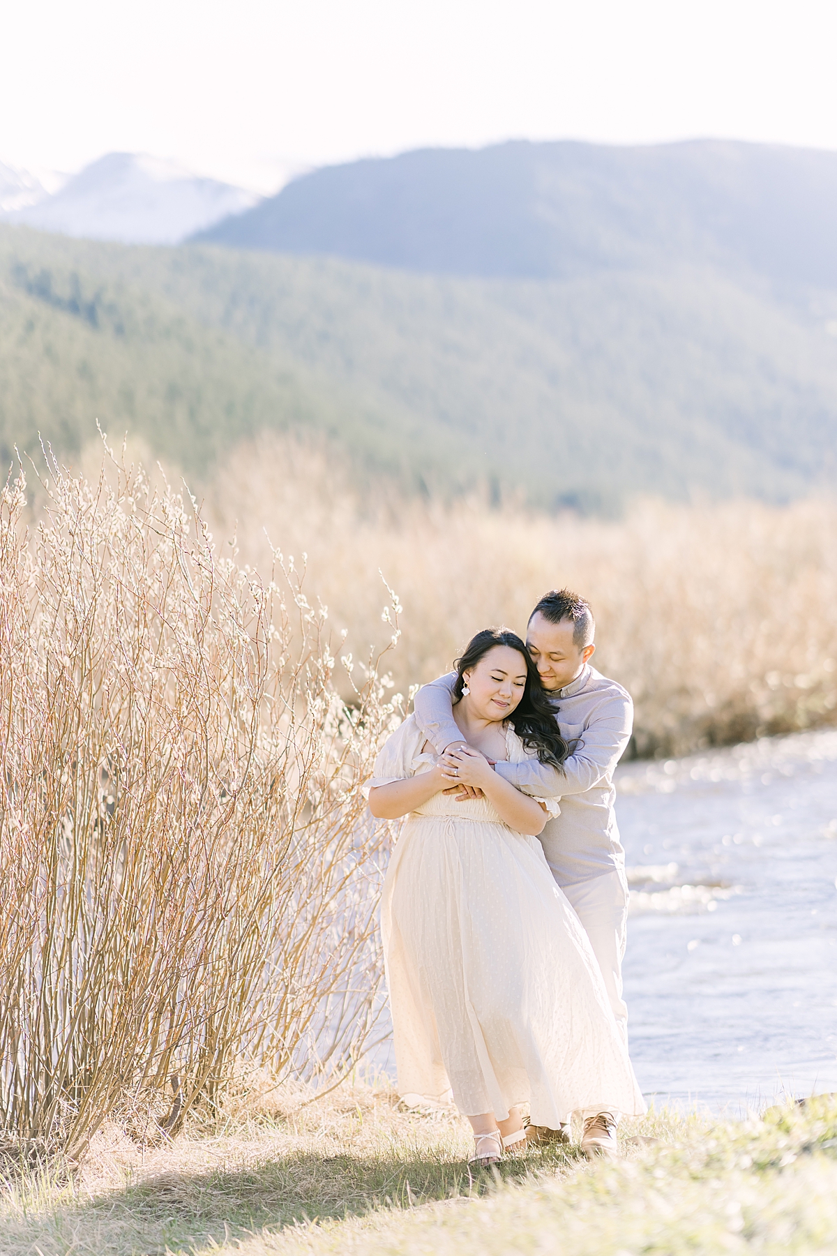 A sweet couple in neutrals hugs in Rocky Mountain National Park.