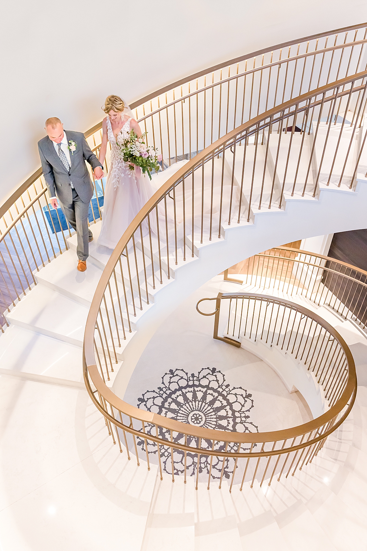 bride and groom walk down the staircase at the elizabeth hotel wedding