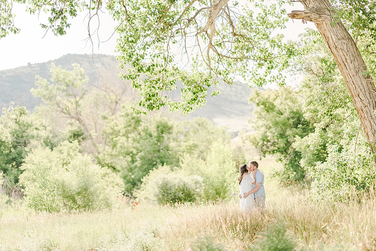 A sweet couple kisses under a tree at Hildebrand Ranch.