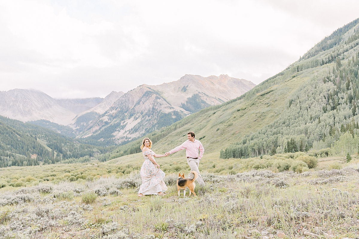A couple walks through the mountains with their dogs in Aspen.