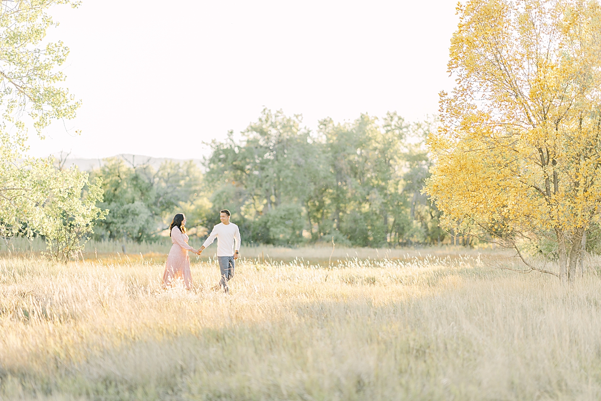 A nice couple walks in the park at Crown Hill Park for Denver engagement portraits.