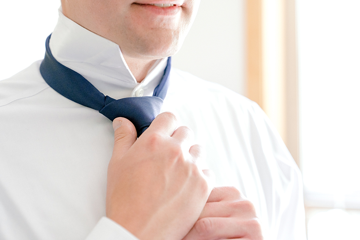 A groom ties his tie in Breckenridge.