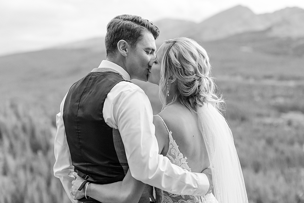 A bride and groom kiss at their summer wedding photographed by Breckenridge wedding photographer.