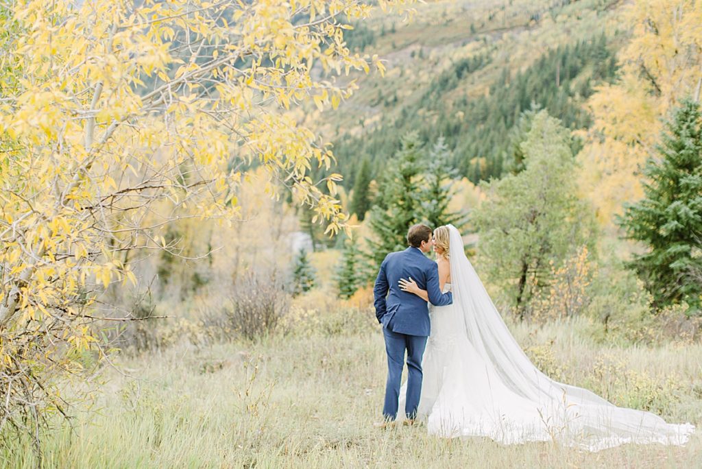 Bride and groom hug by the Crystal River in Marble, CO.