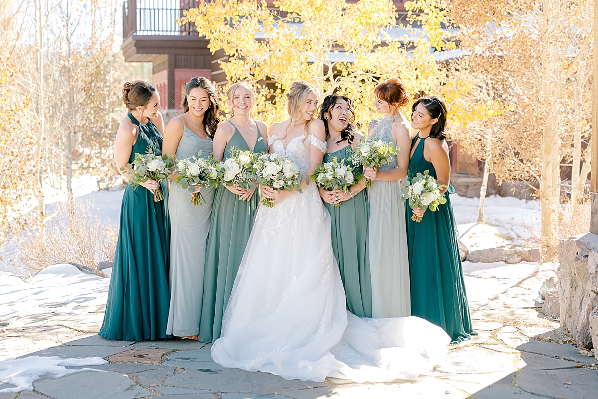 A bride and bridesmaids in front of a yellow aspen tree