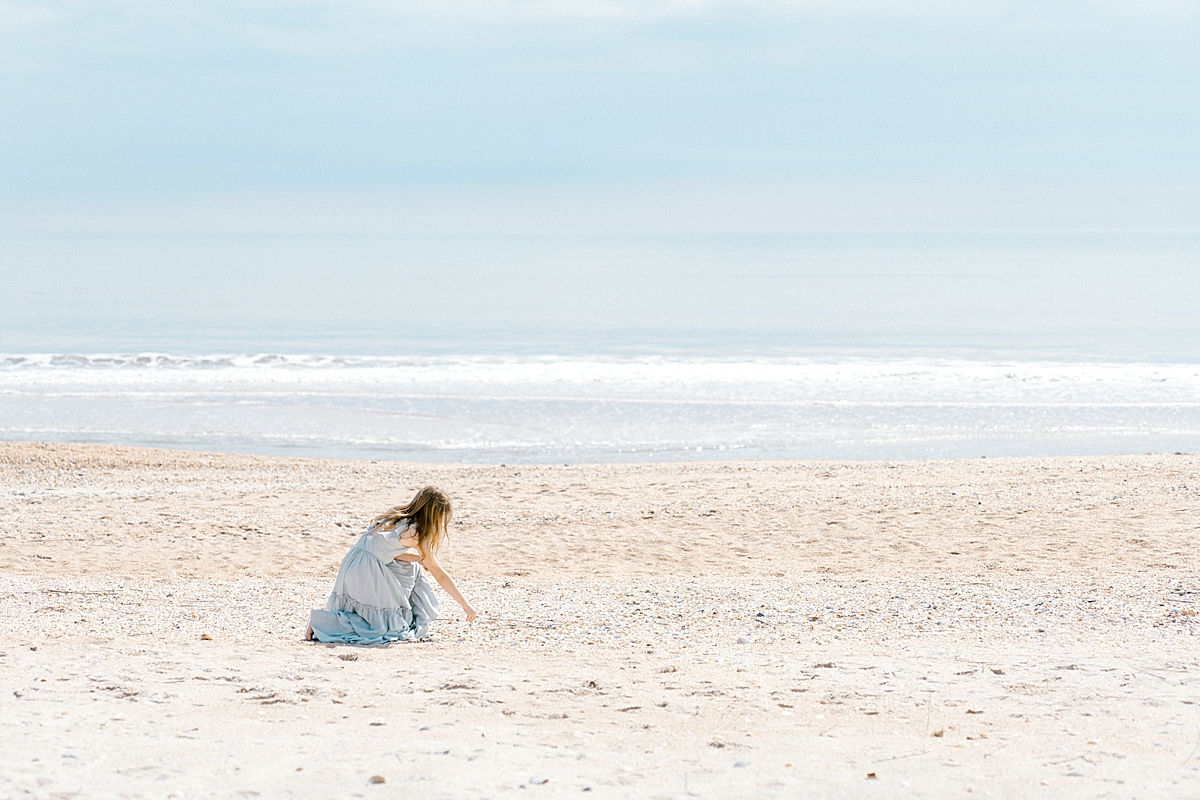 A young girl picks up shells on a northeast Florida beach.