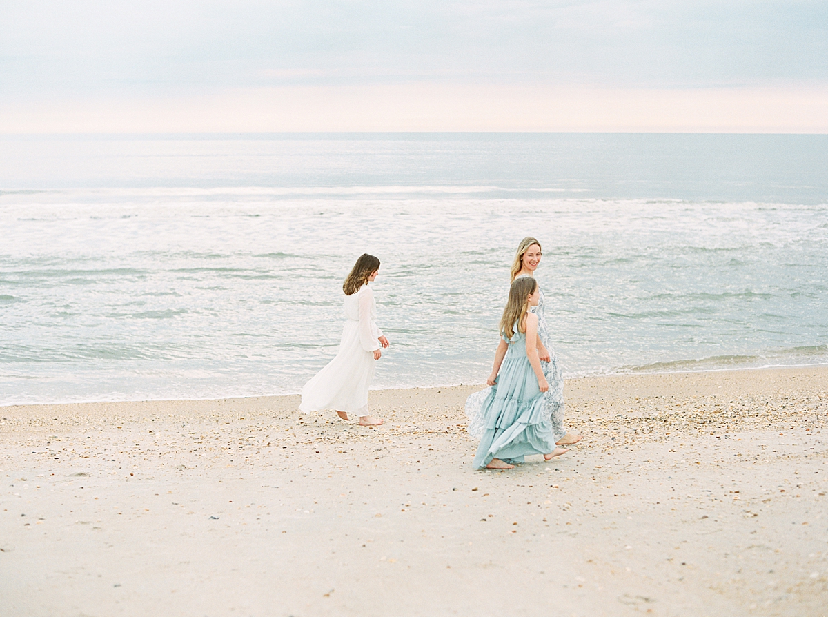 A mom and two daughters walk along the beach in Jacksonville, FL.