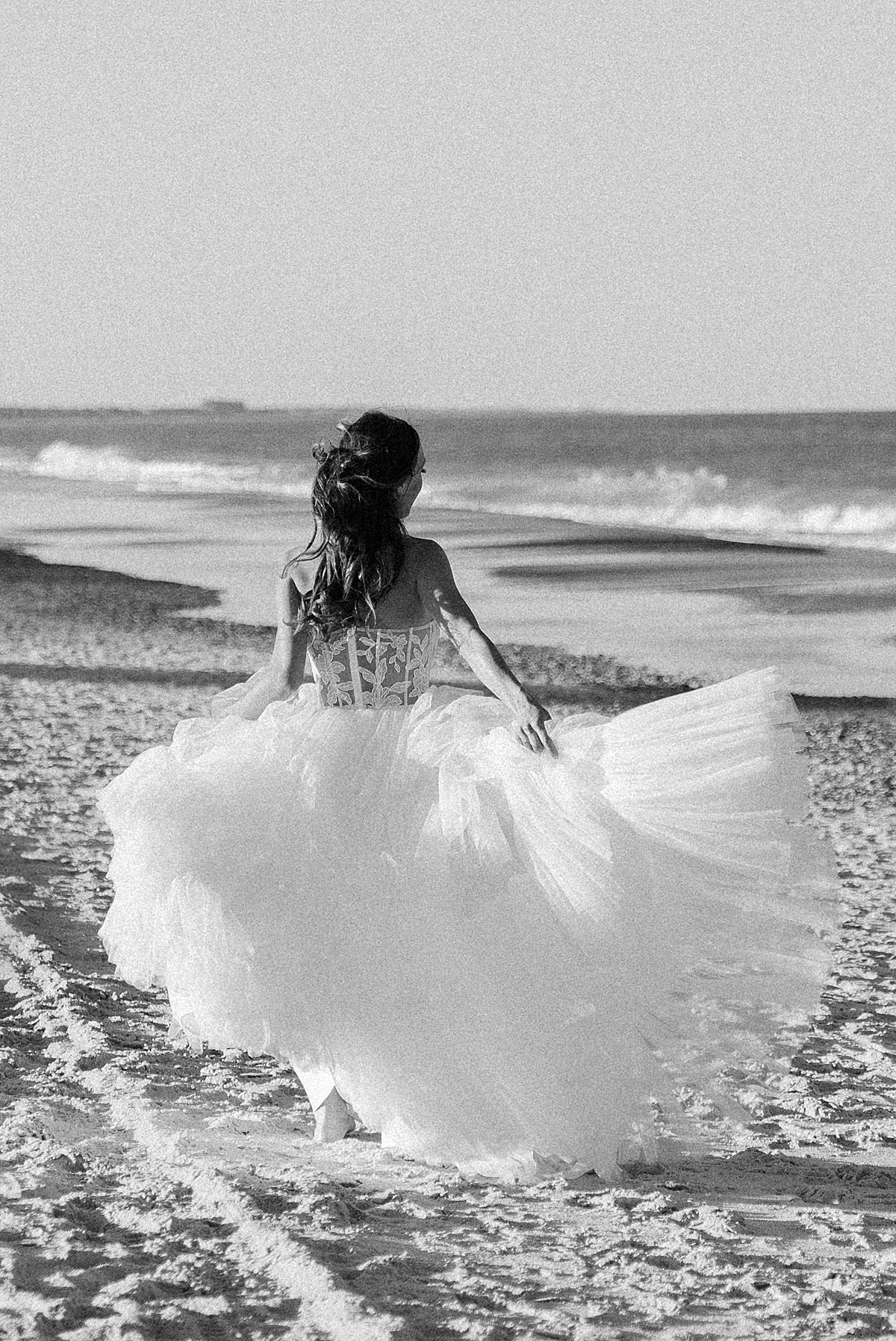 A bride runs along the beach in Florida as her dress flies behind her.