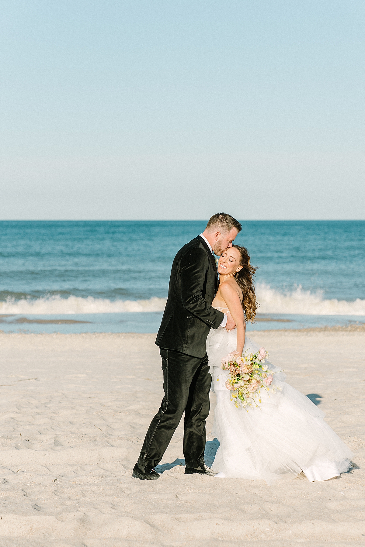 modern beach destination wedding couple embrace by the waves in Florida.
