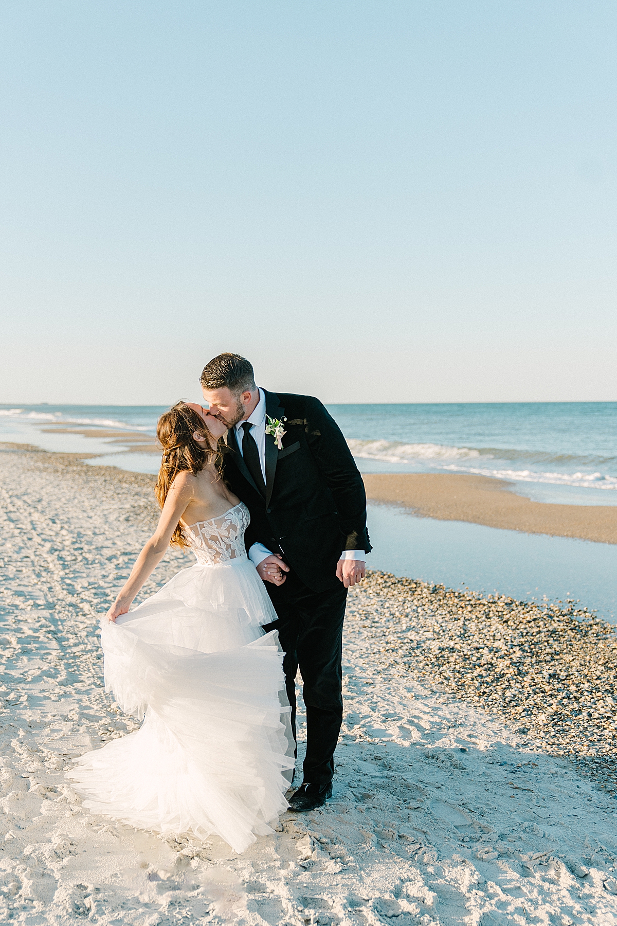 A bride and groom kiss on the beach in Florida.