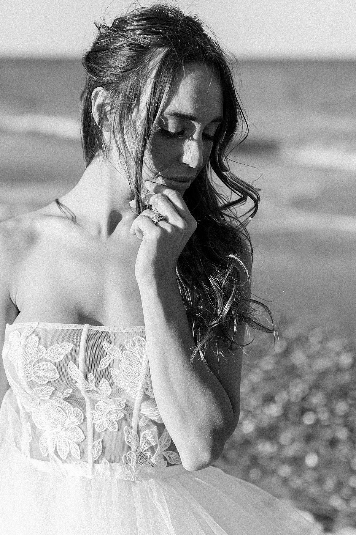 A bride poses on the beach in an Elizabeth Leese wedding dress.