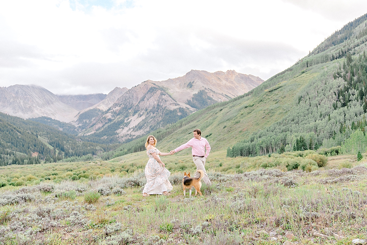 A couple walks through the mountains with their dogs for Aspen Colorado engagement photos in the Ashcroft valley.