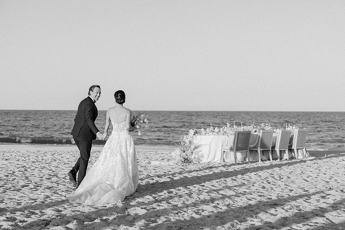 A couple walks to their luxury beach wedding on film reception