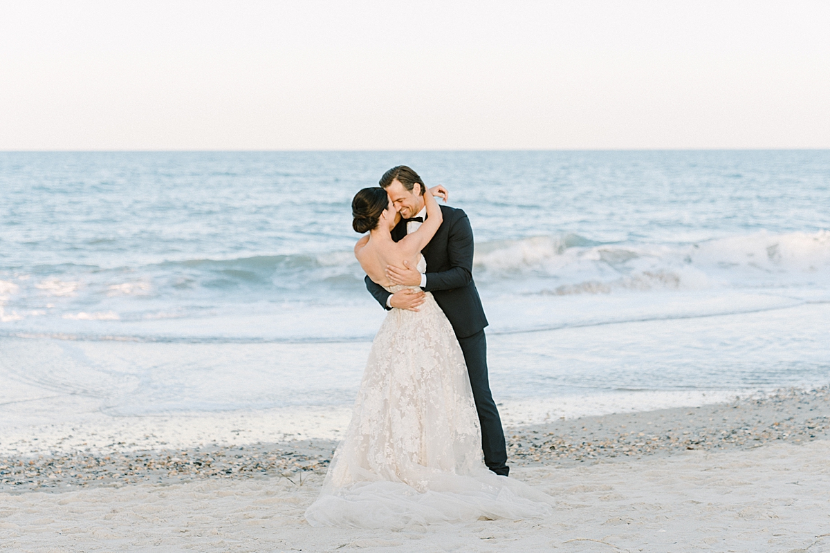 A bride and groom kiss at their luxury beach wedding.