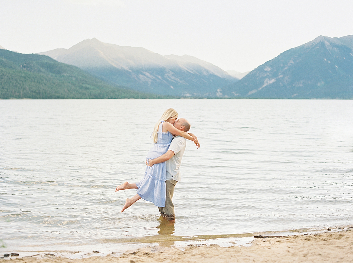 A couple kisses in a lake by the mountains in Aspen Colorado.