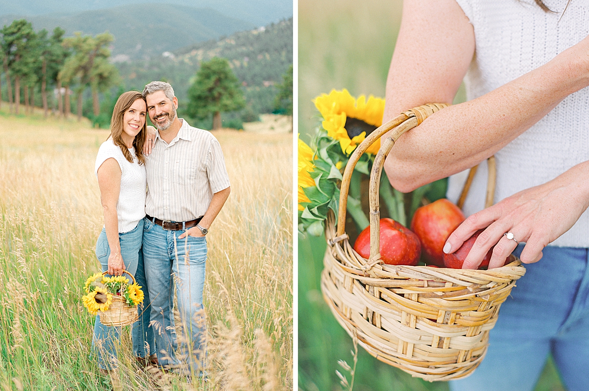 An engaged couples poses with sunflowers and a basket of apples in Boulder.