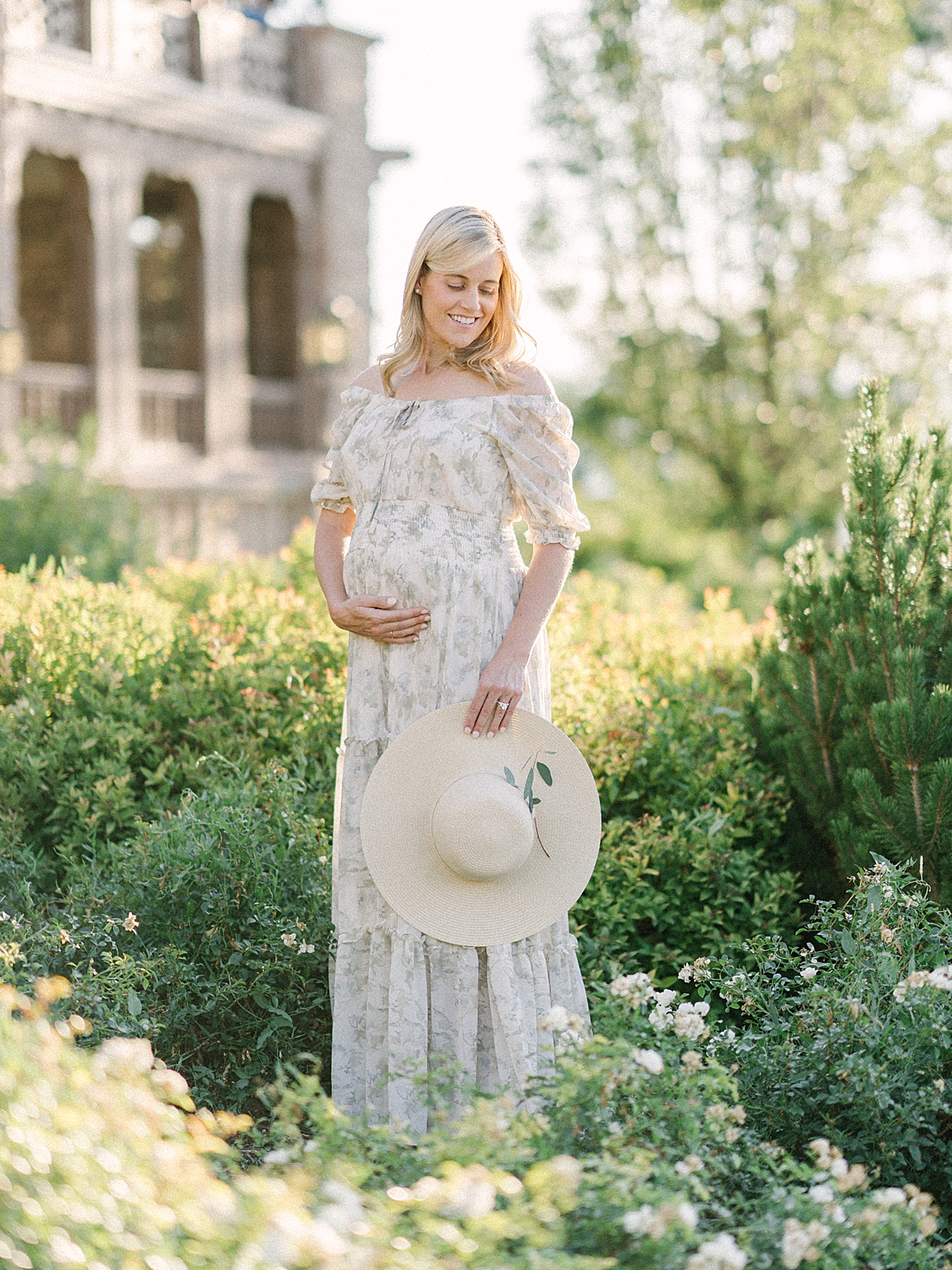 A pregnant woman takes summertime maternity photos at the Highlands Ranch Mansion.
