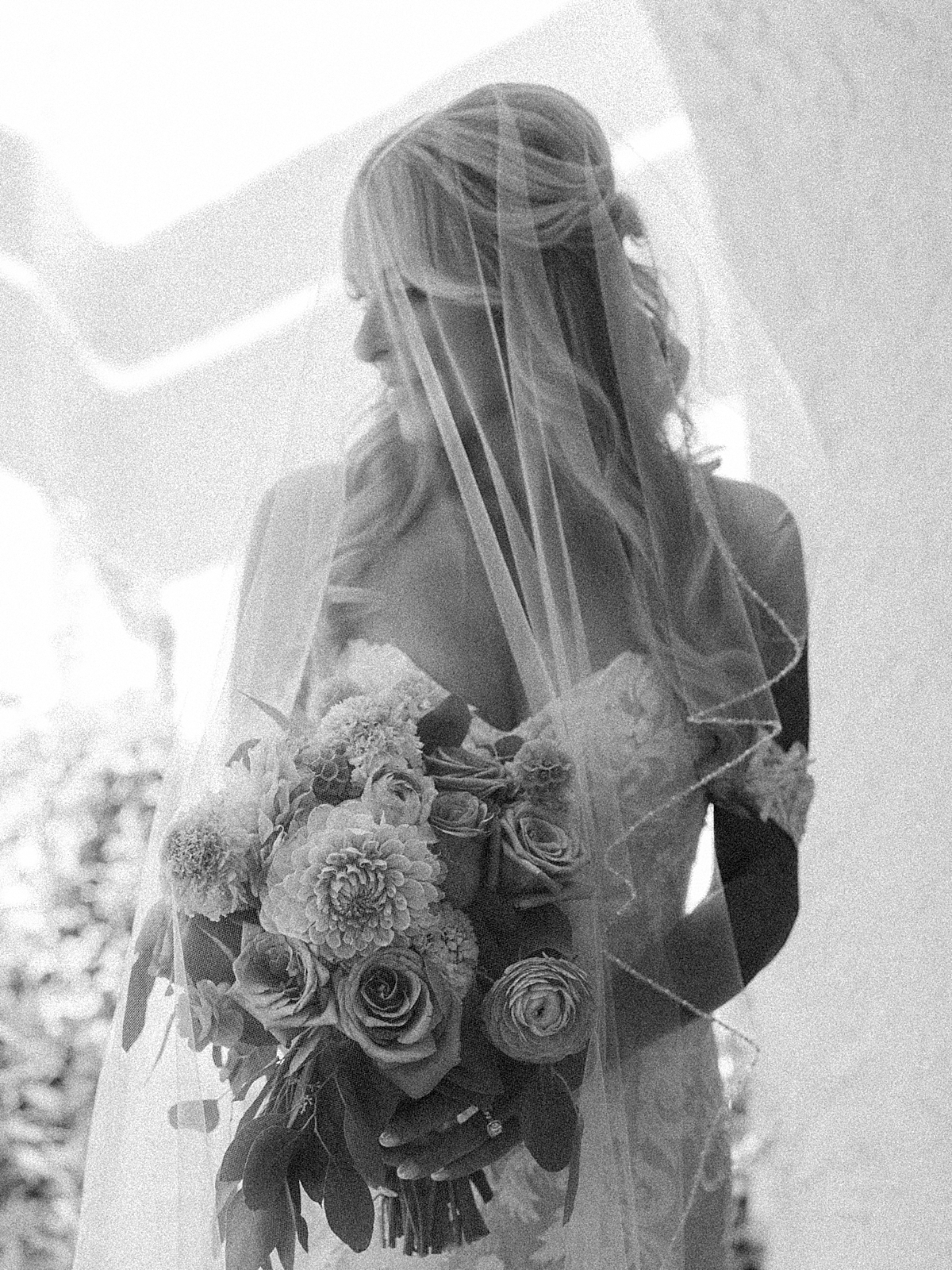 slightly out of focus black and white of a bride under a veil