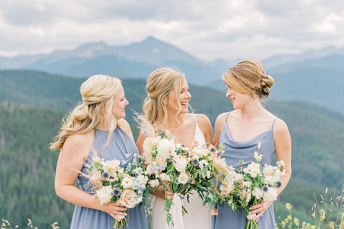 A bride laughs with her bridesmaids on Vail mountain.
