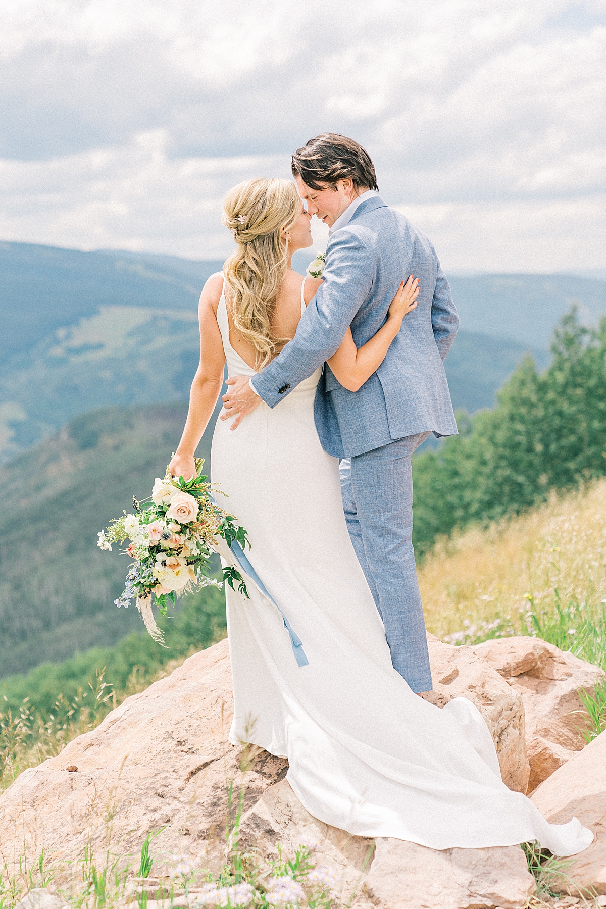 Vail mountain kissing from a summer bride and groom.