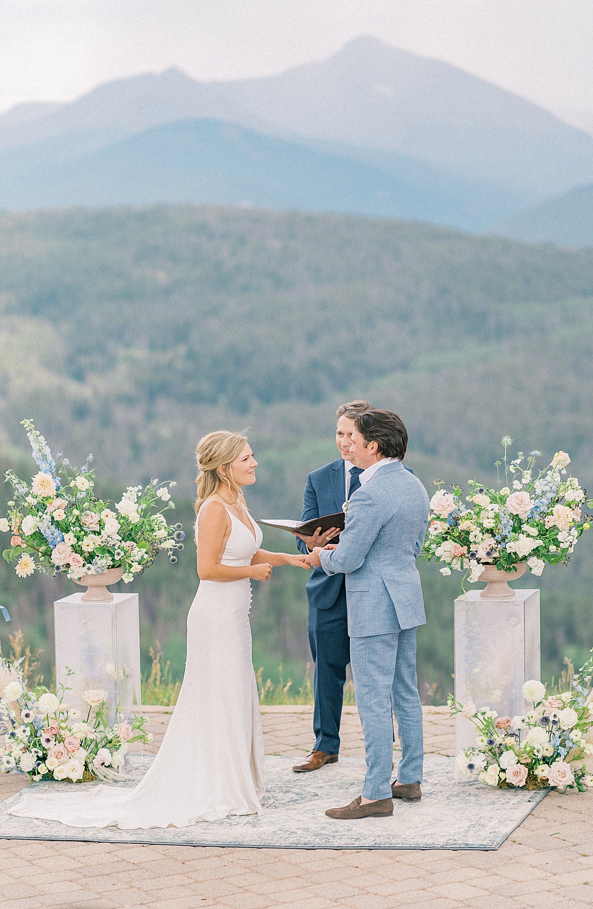 This is a beautiful wedding ceremony in shades of dusty blue atop Vail mountain at the Vail mountain wedding deck.