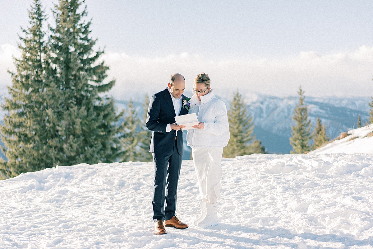 A bride and groom get ready to sign their  marriage license in the snow in Aspen.