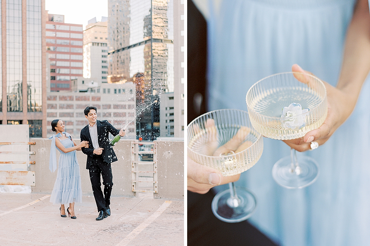A couple dressed in a suit and blue dress do a champagne pop to celebrate their engagement.