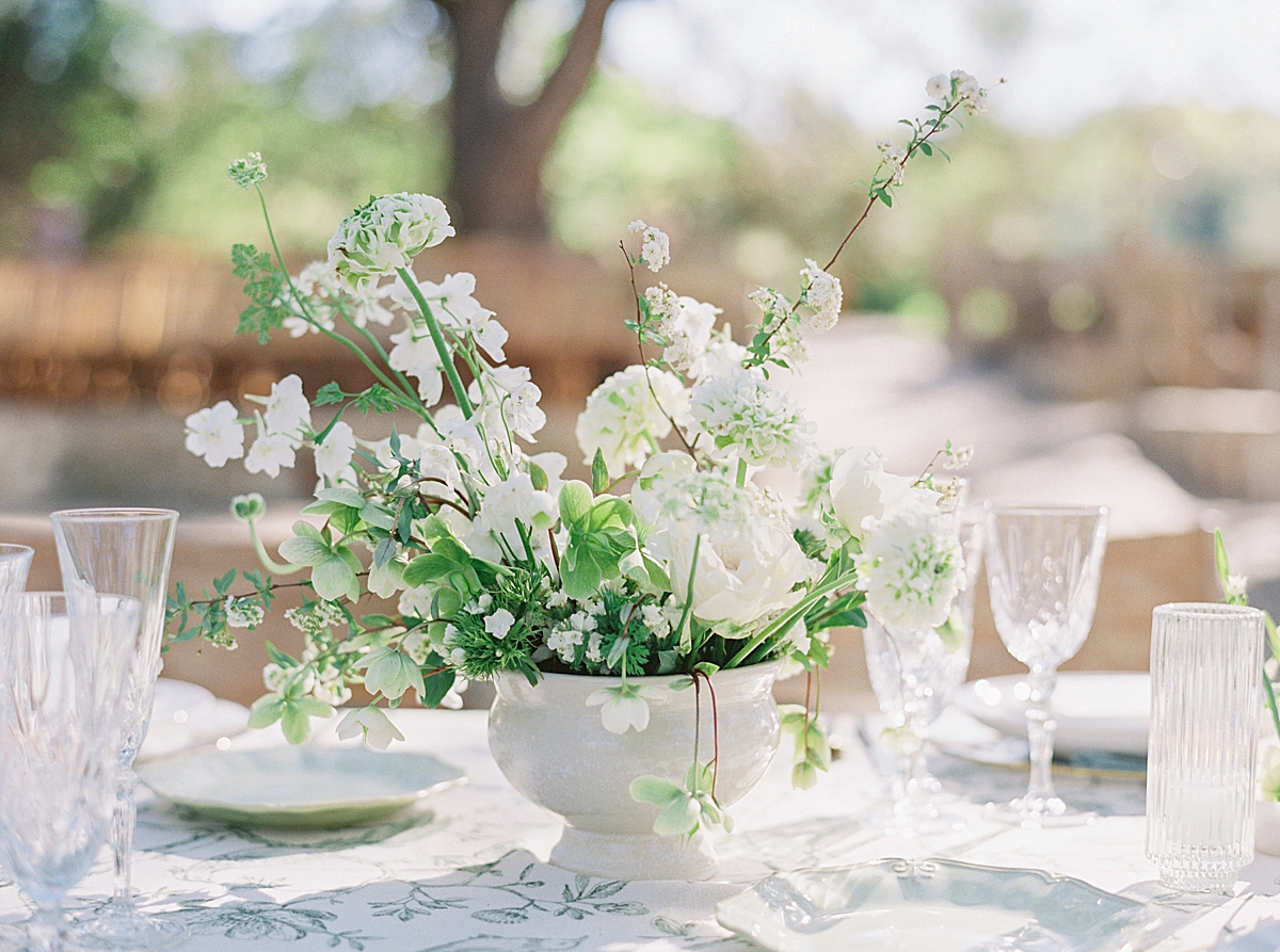 A centerpiece of beautiful white flower sits on table linens from Nüage