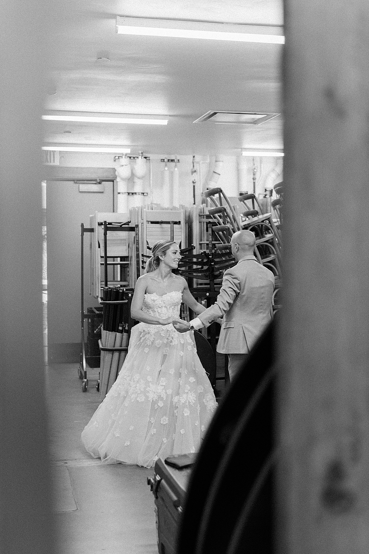 A bride and groom practice their first dance in the storage room
