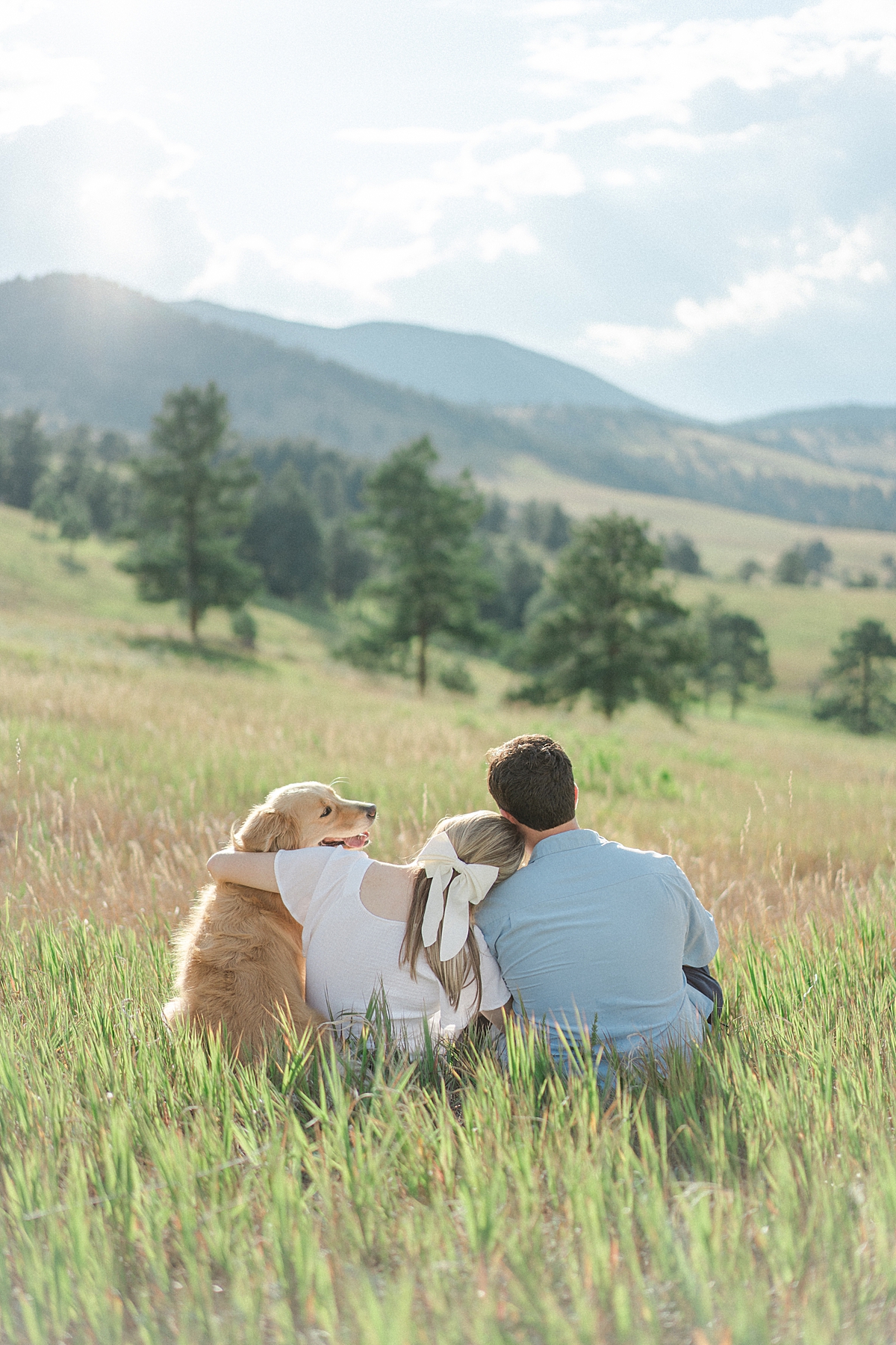 A couple poses for Boulder engagement photos with their golden retriever dog.