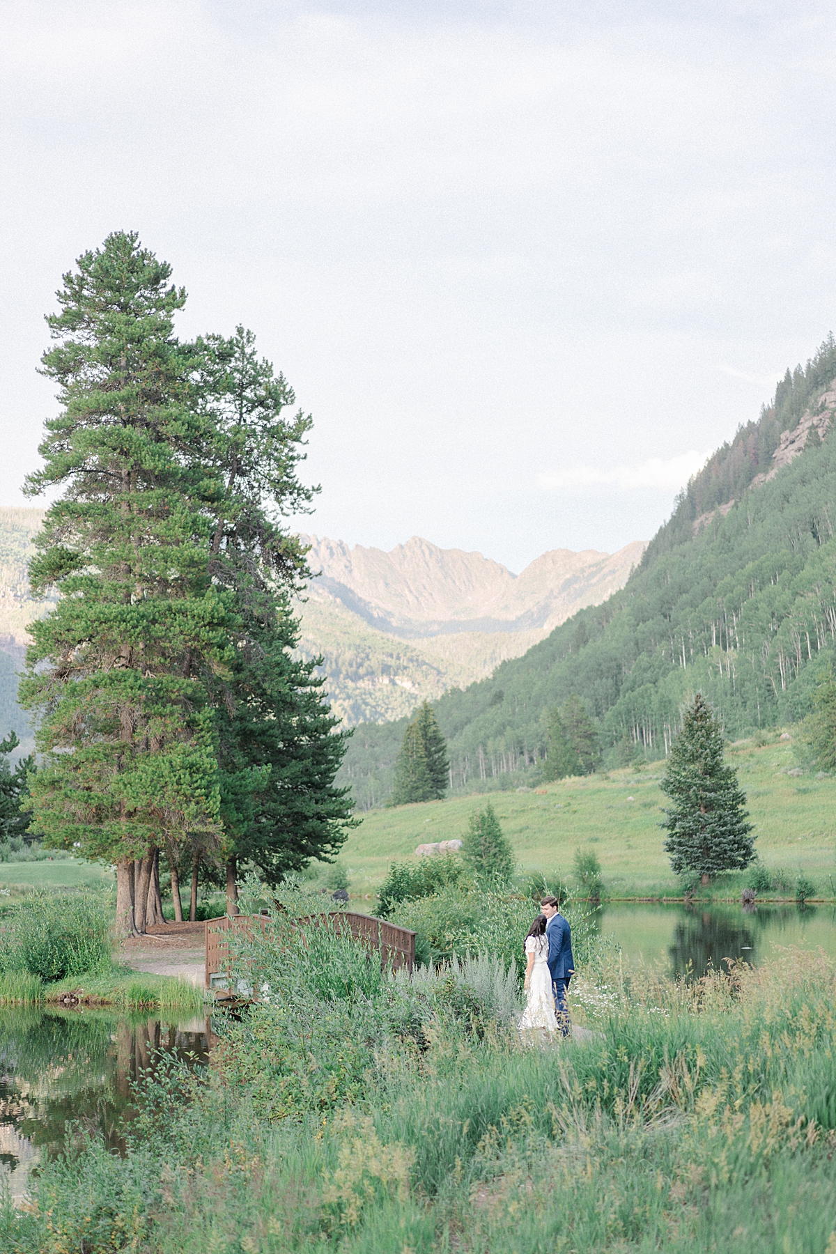 Vail engagement photographer takes engagement photos of a couple at the Vail golf club with the Gore mountain range.