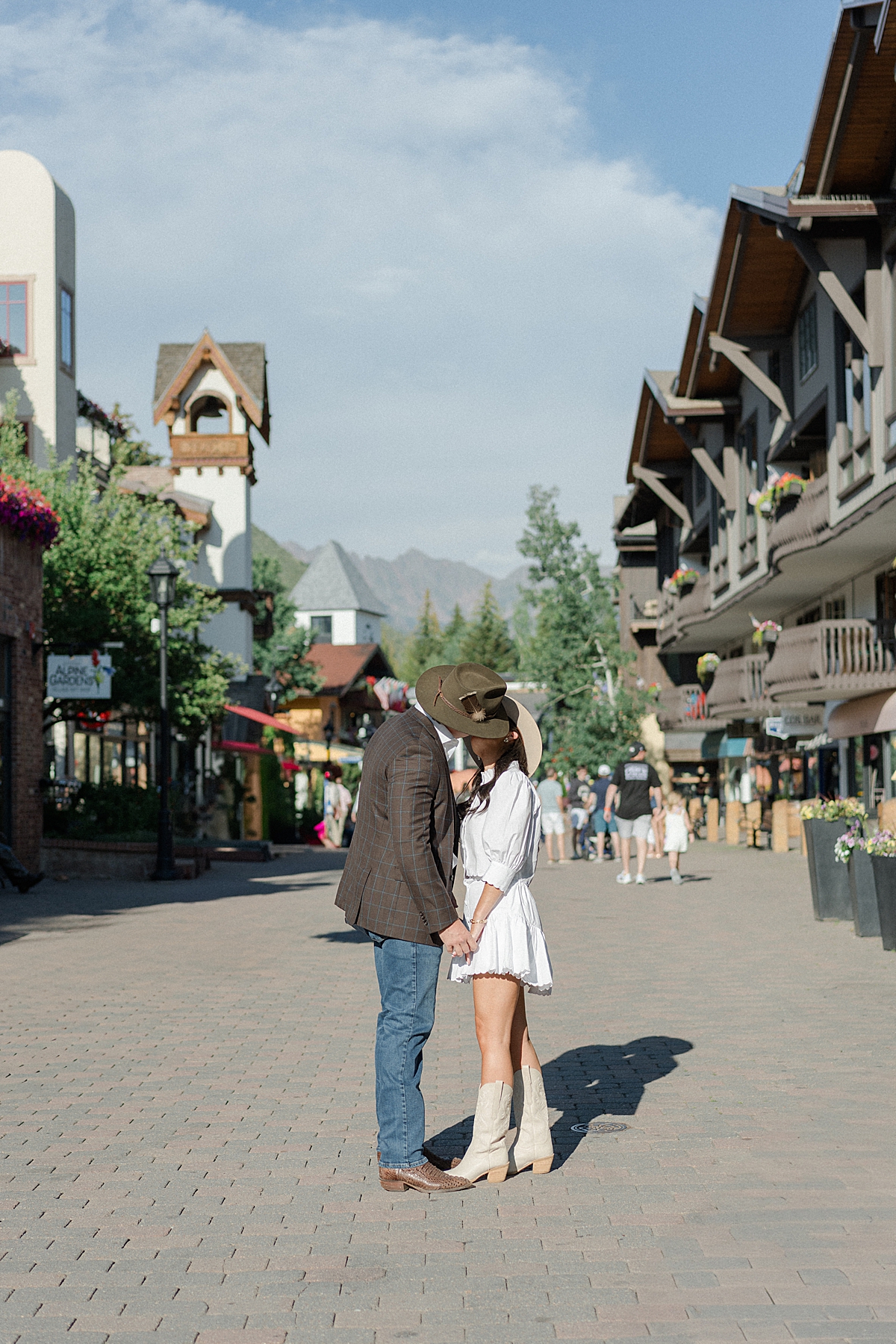 Direct sun engagement photos in Vail Village with the Gore mountain range, taken by a Vail engagement photographer.