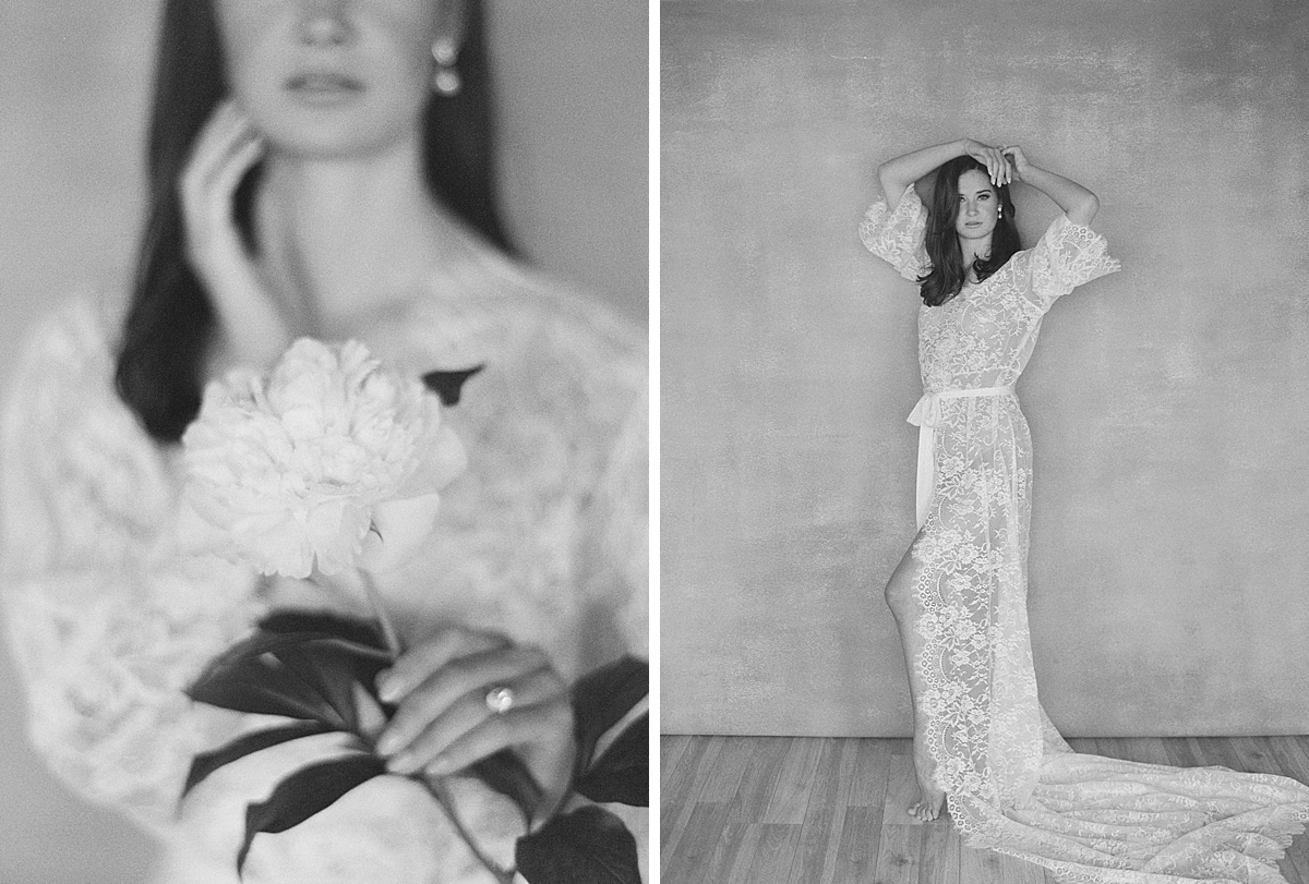 A woman holds a white peony and poses for black and white film boudoir photography