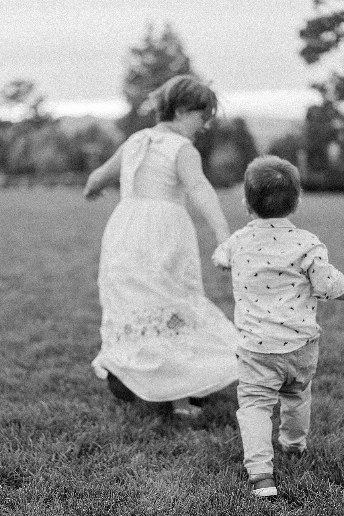 Two young kids run in the lawn at the Highlands Ranch Mansion.