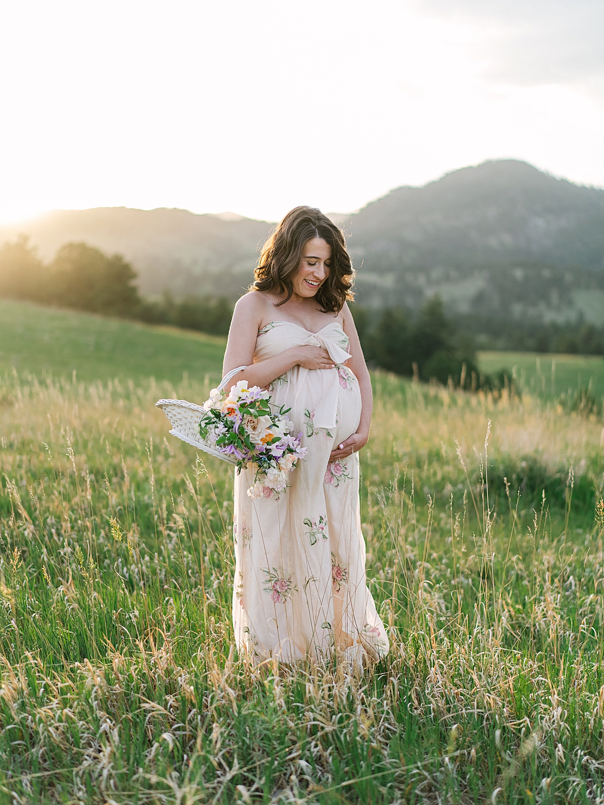 expecting mother in floral dress for Colorado maternity session