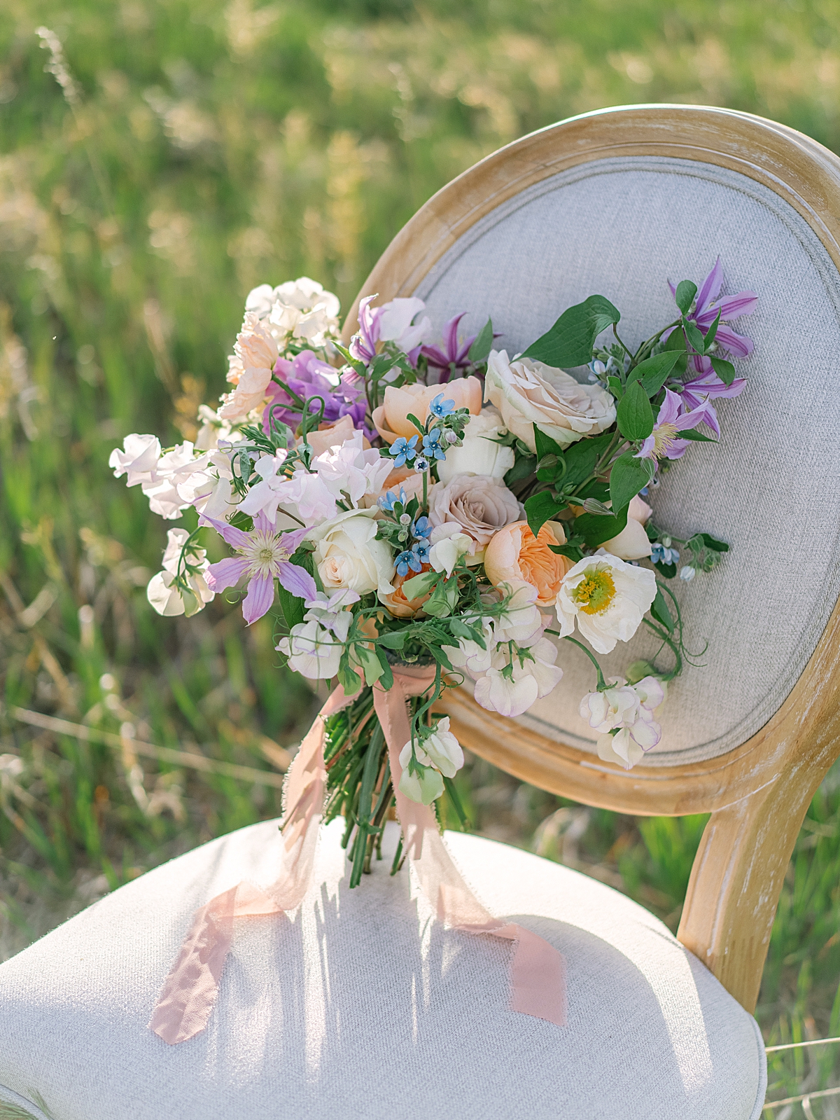floral bouquet with roses, poppies, sweet pea, clematis, and tweedia